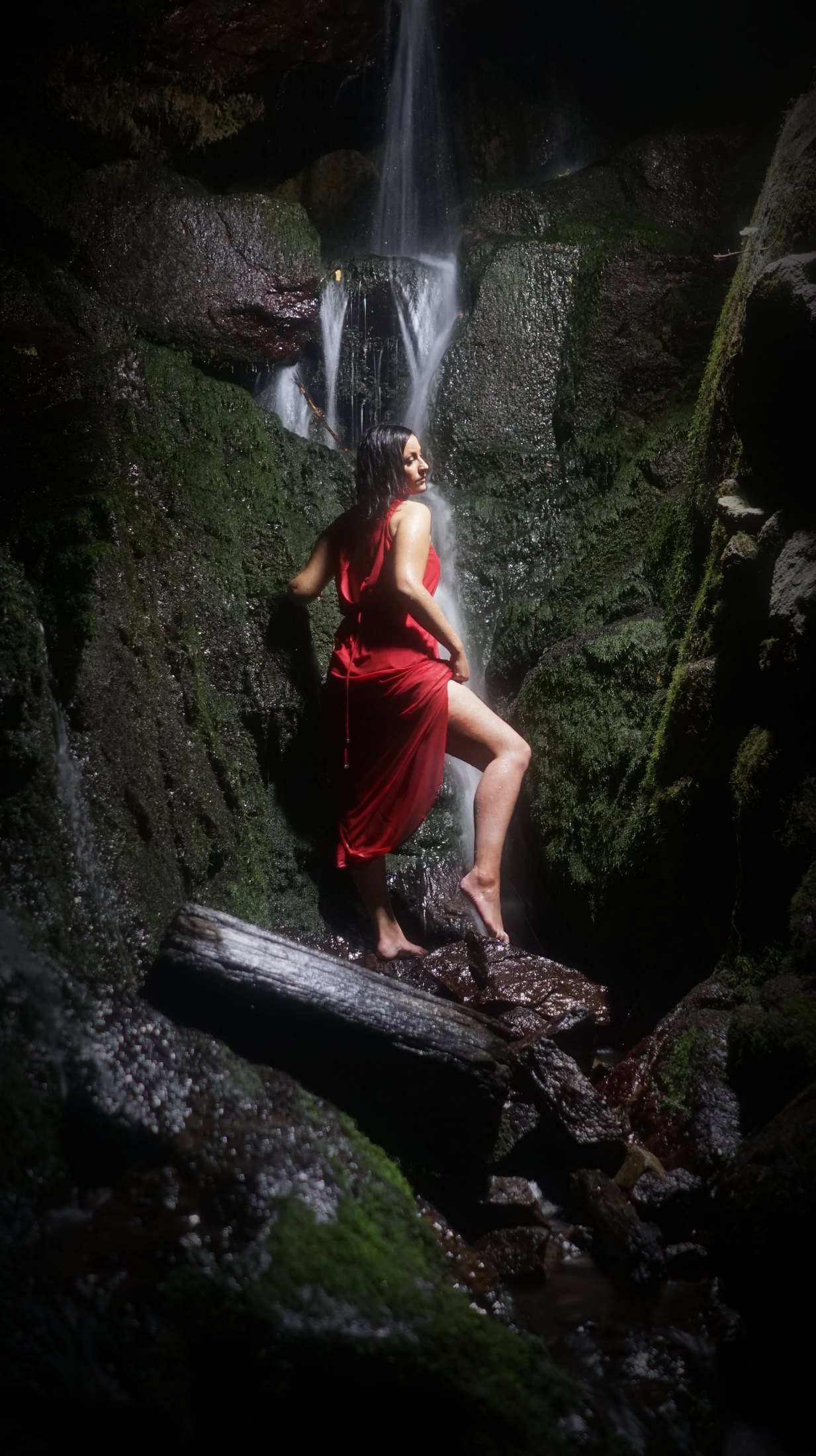 Robe rouge sous la cascade